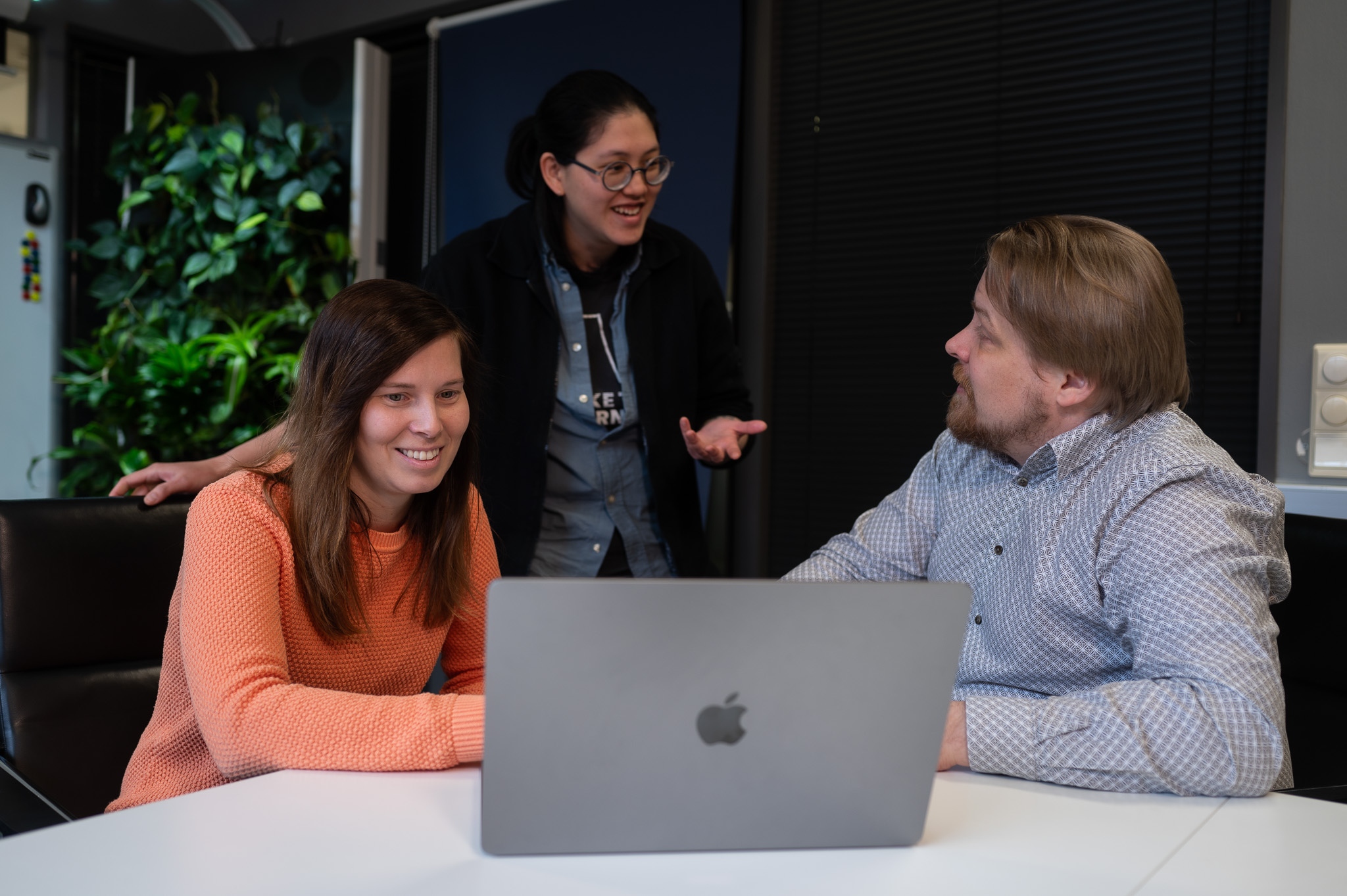 Three people working with laptop