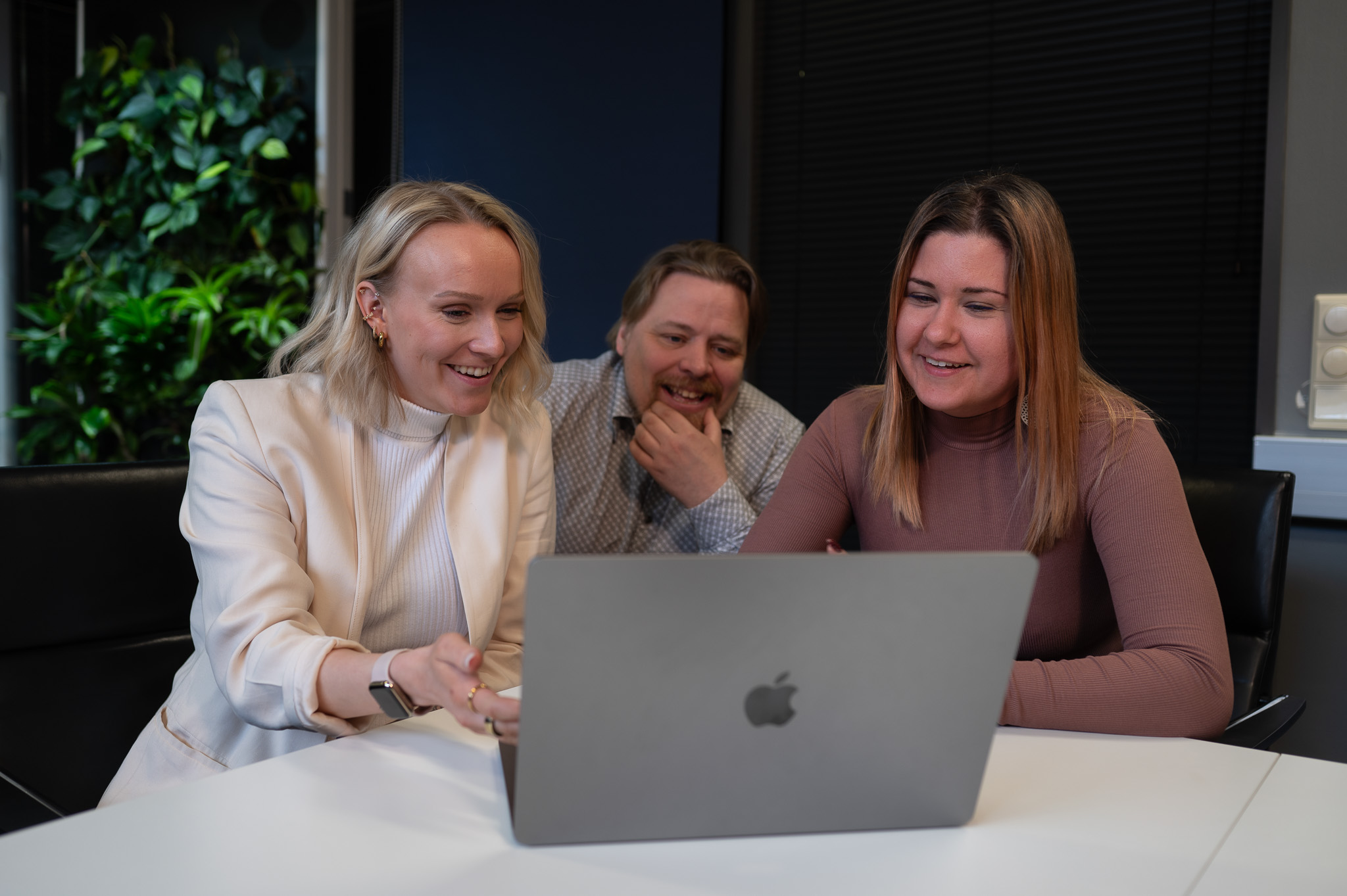 Two women and one man working together in the meeting room.