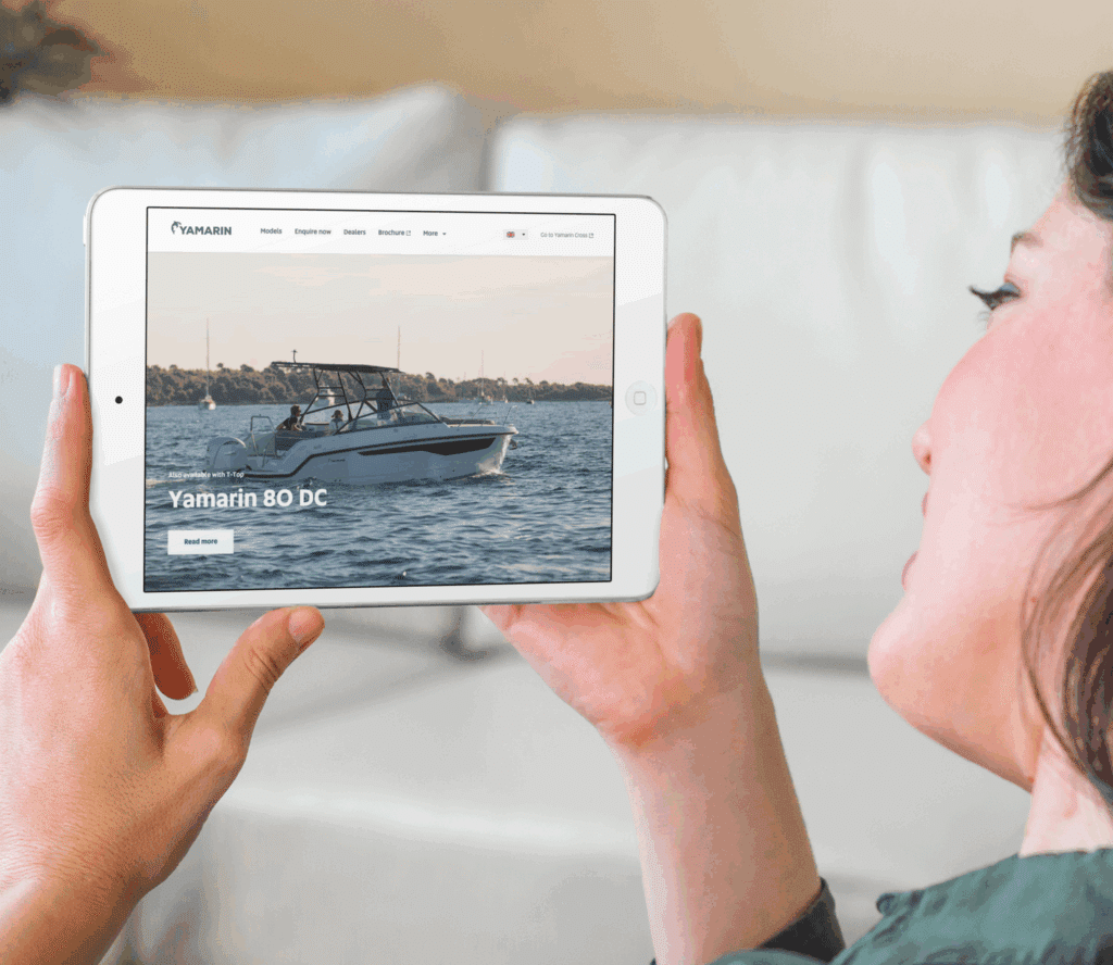Nainen tutkii tabletilta Yamarin 80 DC -veneen sivua.