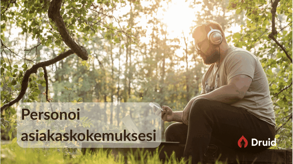 Mies istuu metsässä ilta-auringon valossa, kuulokkeet päässä ja älypuhelin kädessään, edessään kannettava tietokone. Kuvan alareunassa on teksti ‘Personoi asiakaskokemuksesi’ ja oikeassa alakulmassa Druidin logo.