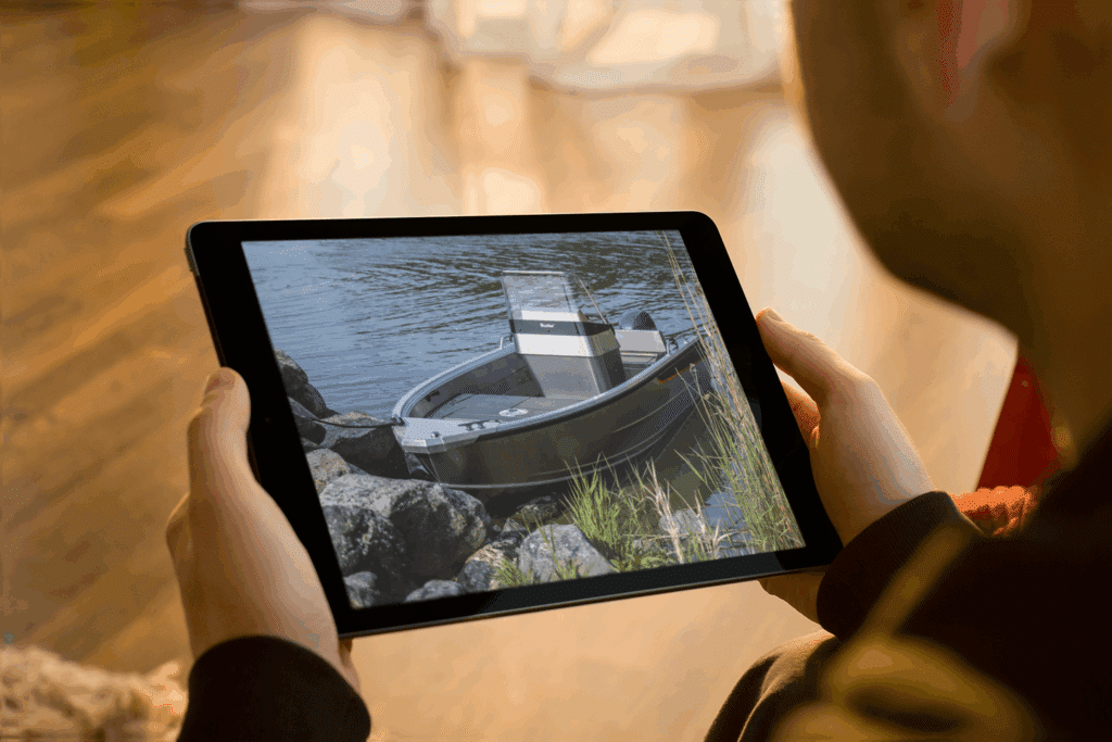 Mies pitää tablettia kädessä. Näytöllä näkyy Buster-veneen kuva