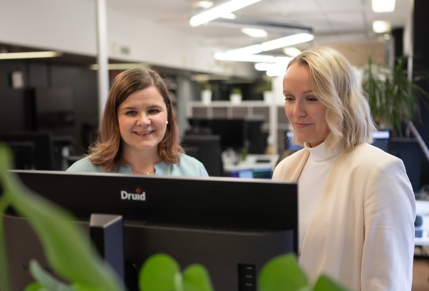 Two women behing the screen at the office,